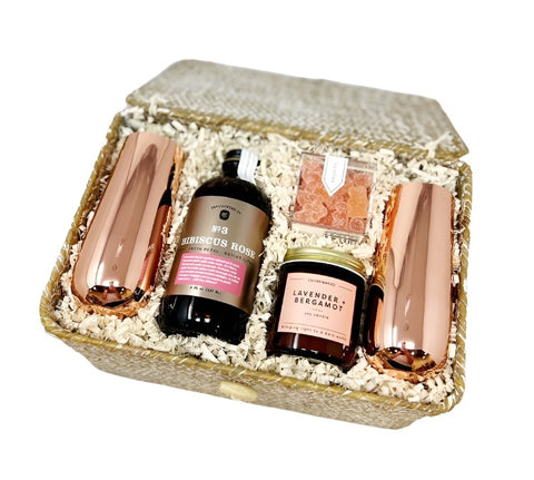 poppin' bottles gift basket with champagne flutes, hibiscus rose cocktail mix, sparkling rosé gummy bears and a lavender candle