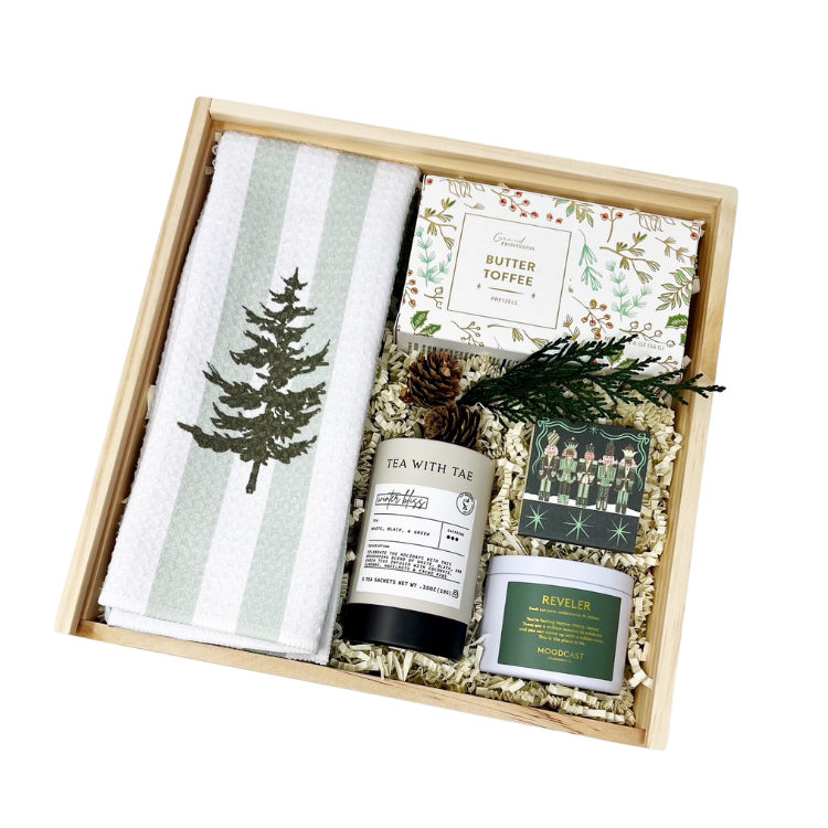 holiday gift box with decorative tea towel, pine scented candle, winter bliss tea, butter toffee pretzels and nutcracker matchbook in a wooden gift box