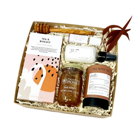 wellness gift set with chocolate, honey, tea, drizzle stick, lavender lotion and feel good oil.