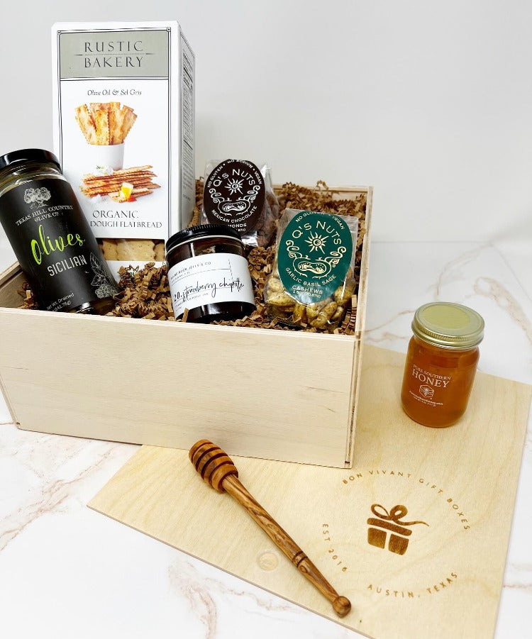 gift box with crackers, olives, nuts, strawberry chipotle jam and honey