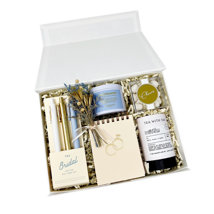 bride to be engagement gift box with a set of bridal pens and a matching notepad, a daydreamer candle, sweets and wedded bliss tea with a handmade dried floral bundle