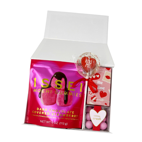 valentine's day gift box with dark chocolate strawberry mochi gummies, shower steamers, a conversation heart lollipop and cocoa crush brownie bites