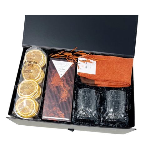 gift box includes set of crystal glass rocks glasses, burnt orange crew socks, whiskey infused dark chocolate bar, dried lemon slices