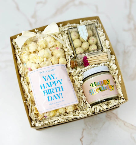 Birthday gift box with confetti popcorn, birthday candle, birthday cake cookie bites and matches