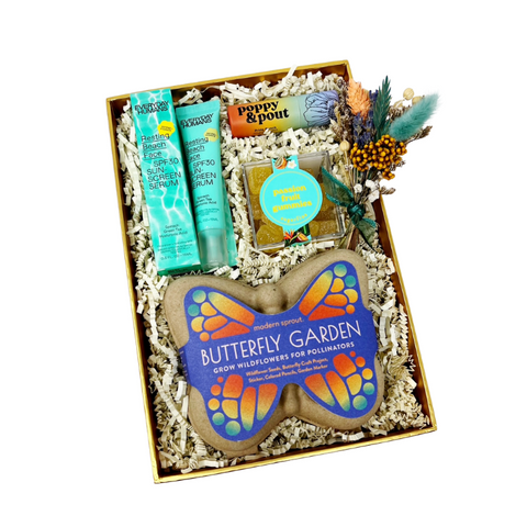 summer themed birthday gift box with butterfly garden, passionfruit gummies, spf face serum, lip balm, handmade dried floral bundle, handwritten card in a gold gift box.