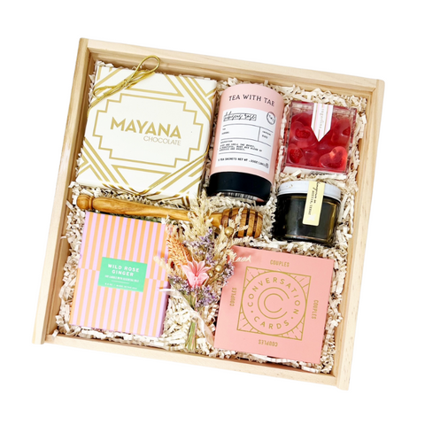 valentine's day gift box with bonbons, strawberry heart gummies, hibiscus rose tea, honey, honey drizzle stick, couples conversation cards, wild rose + ginger candle and dried floral bundle