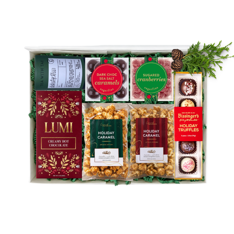 shareable holiday gift basket with holiday flavored treats like caramel popcorn, hot cocoa mix, tea, holiday truffles, caramels and sugared cranberries.