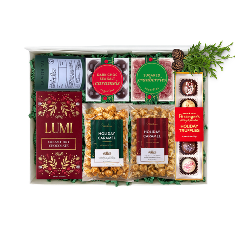 shareable holiday gift basket with holiday flavored treats like caramel popcorn, hot cocoa mix, tea, holiday truffles, caramels and sugared cranberries.