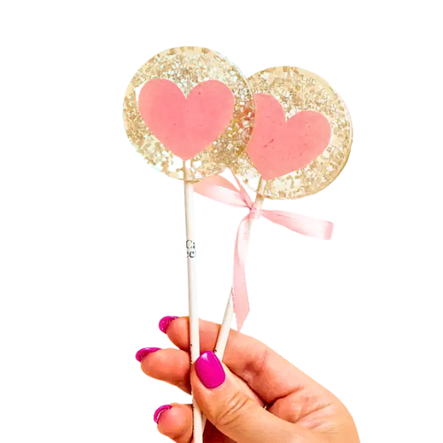 Individually wrapped champagne flavored lollipops. A blush pink glitter heart, surrounded by clear candy filled with shimmery silver sugar crystals. 
Made in the United States.
All lollipops are vegan, gluten free, dairy free, and nut free.
Dimensions: 2 1/4” in diameter
Flavor: Champagne
Size: 1.3 oz (36g).
Branded Stick: 6" long, 5 /32" thick