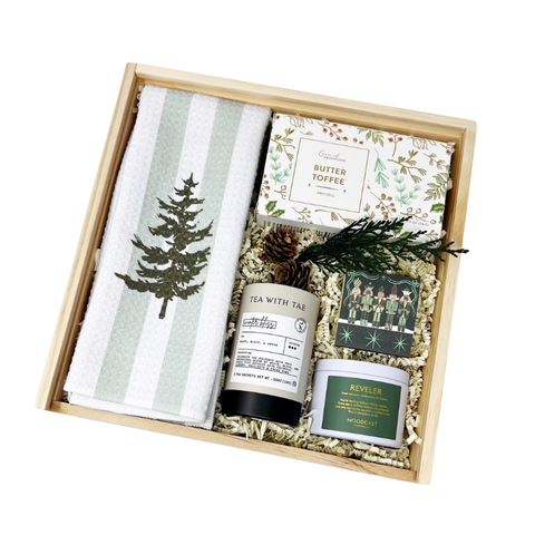holiday gift box with decorative tea towel, pine scented candle, winter bliss tea, butter toffee pretzels and nutcracker matchbook in a wooden gift box