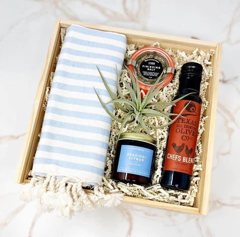 welcome home housewarming gift box with striped hand towel, extra virgin olive oil, herbed finishing salt, seaside + citrus soy candle, air plant