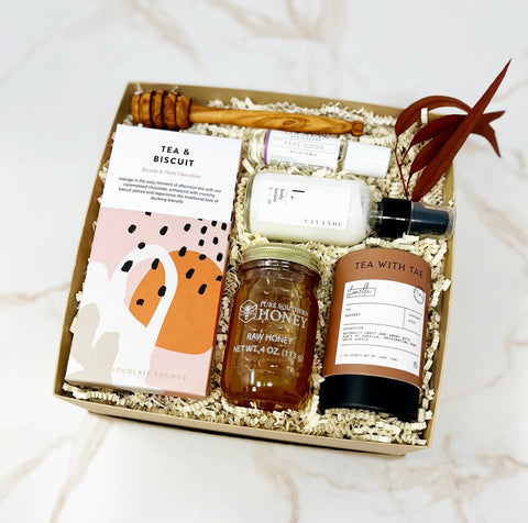 wellness gift set with chocolate, honey, tea, drizzle stick, lavender lotion and feel good oil.